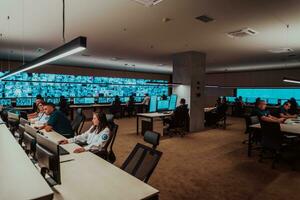 Group of Security data center operators working in a CCTV monitoring room looking on multiple monitors Officers Monitoring Multiple Screens for Suspicious Activities Team working on the System Contr photo