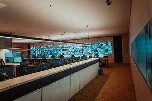 Empty interior of big modern security system control room, workstation with multiple displays, monitoring room with at security data center Empty office, desk, and chairs at a main CCTV security data photo