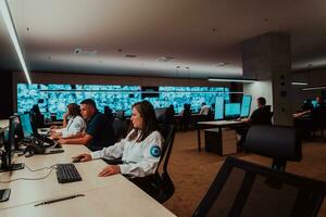 Group of Security data center operators working in a CCTV monitoring room looking on multiple monitors Officers Monitoring Multiple Screens for Suspicious Activities Team working on the System Contr photo