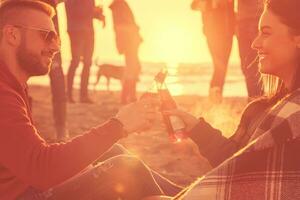 Couple enjoying with friends at sunset on the beach photo