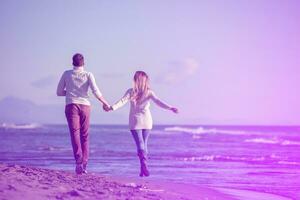Loving young couple on a beach at autumn sunny day photo