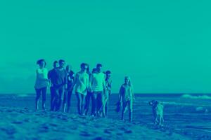 Group of friends running on beach during autumn day photo