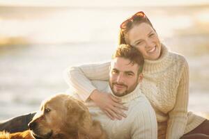 Couple with dog enjoying time on beach photo