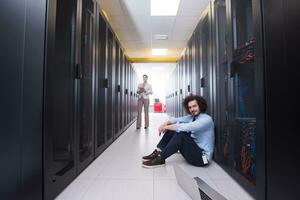 Team of young technicians working together on servers photo