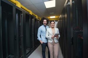 engineer showing working data center server room to female chief photo