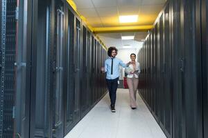 engineer showing working data center server room to female chief photo