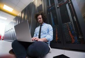 ingeniero que trabaja en una computadora portátil en la sala de servidores foto