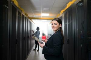 Female engineer working on a tablet computer in server room photo