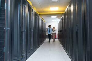 engineer showing working data center server room to female chief photo