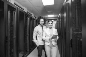 engineer showing working data center server room to female chief photo