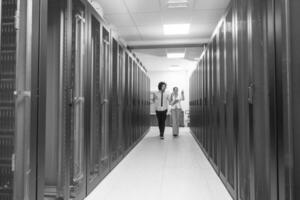 engineer showing working data center server room to female chief photo