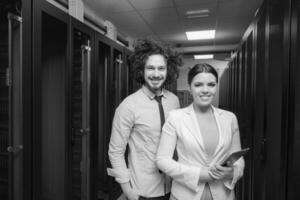 engineer showing working data center server room to female chief photo