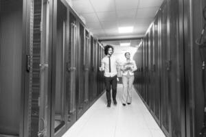 engineer showing working data center server room to female chief photo