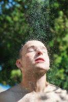 hombre lavar cabeza debajo ducha con que cae agua foto