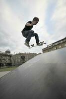 Boy practicing skate in a skate park photo