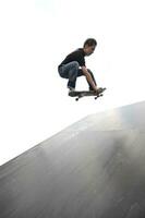 Boy practicing skate in a skate park photo