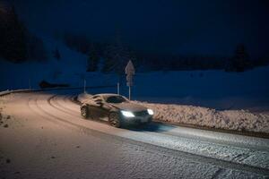 car driving on dangerous road at night on snow photo