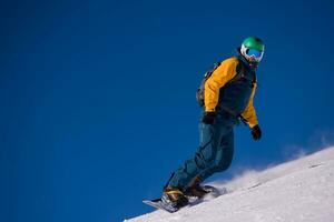 snowboarder running down the slope and ride free style photo