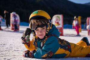 pequeño snowboarder acostado en el nieve foto