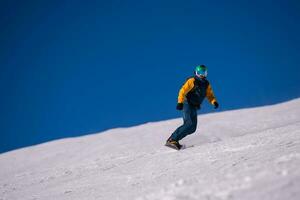 snowboarder running down the slope and ride free style photo