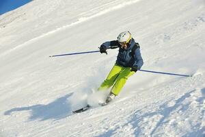 skiing on fresh snow at winter season at beautiful sunny day photo