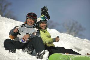 pareja de snowboarders relajante foto