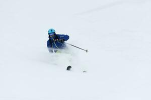 esquiador de freeride esquiando en nieve polvo profunda foto