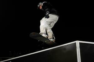 freestyle snowboarder jump in air at night photo