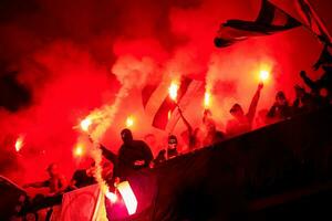 football hooligans with mask holding torches in fire photo