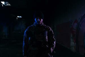 Ejército soldado en combate uniformes con un asalto rifle y combate casco noche misión oscuro antecedentes. azul y púrpura gel ligero efecto. foto