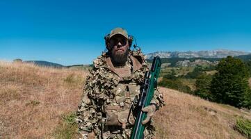 Ejército soldado participación un francotirador rifle con alcance y caminando en el bosque. guerra, ejército, tecnología y personas concepto. foto