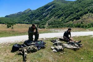 especial operaciones soldados equipo preparando táctico y comunicación engranaje para acción batalla. largo distancia francotirador equipo en comprobación engranaje para acción foto