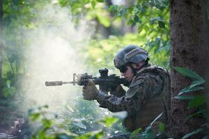 soldier in action aiming  on weapon  laser sight optics photo