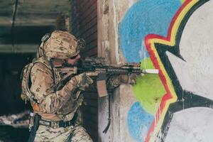 un soldado barbudo con uniforme de fuerzas especiales en una peligrosa acción militar en una peligrosa zona enemiga. enfoque selectivo foto