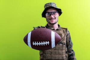 solder holding american football ball photo