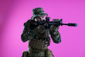 soldier in action aiming laseer sight optics pink background photo