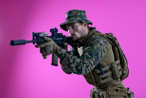 soldier in action aiming laseer sight optics pink background photo