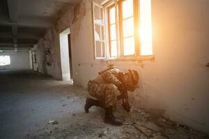 soldier in action near window changing magazine and take cover photo