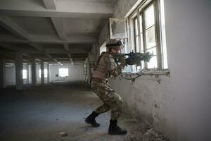 soldier in action near window changing magazine and take cover photo