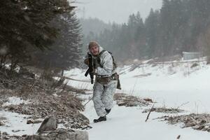 guerra de invierno en las montañas árticas. operación en condiciones frías. soldado en uniforme camuflado de invierno en el ejército de guerra moderno en un día de nieve en el campo de batalla del bosque con un rifle. enfoque selectivo foto