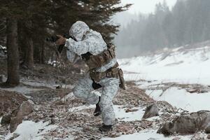 guerra de invierno en las montañas árticas. operación en condiciones frías. soldado en uniforme camuflado de invierno en el ejército de guerra moderno en un día de nieve en el campo de batalla del bosque con un rifle. enfoque selectivo foto