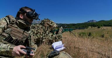 francotirador soldado asistido por un asistente a observar el zona a ser dirigido con moderno guerra táctico virtual realidad gafas de protección aéreo zumbido militar tecnología. foto