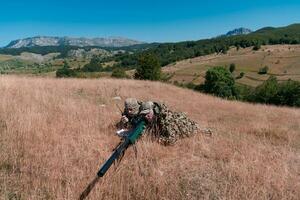 Sniper soldier assisted by an assistant to observe the area to be targeted with modern warfare tactical virtual reality goggles aerial drone military technology. photo