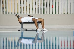 joven hombre ejercicio a junto a la piscina foto