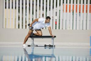 joven hombre ejercicio a junto a la piscina foto