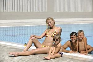 familia joven feliz divertirse en la piscina foto