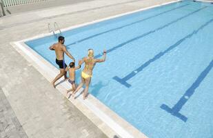 happy young family have fun on swimming pool photo