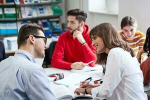 grupo de estudiantes trabajando juntos en un proyecto escolar en una tableta en una universidad moderna foto