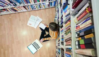 el estudiante usa un cuaderno y una biblioteca escolar foto