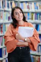 el estudiante usa un cuaderno y una biblioteca escolar foto